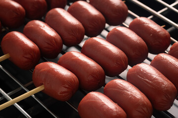 grilled red cocktail sausage skewers on hot electric grill, Thai street food