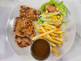 Grilled chicken served with french fries, fresh salad and sauce, casual western meal concept