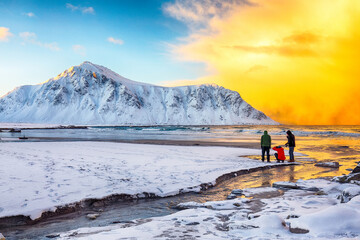Group of tourist looking  on Skagsanden beach with illuminated clouds during sunrise