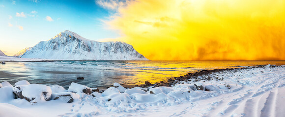 Amazing winter scenery on Skagsanden beach with illuminated clouds during sunrise