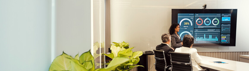 Indian and Asian business professionals in a modern conference room review data and analytics on a...