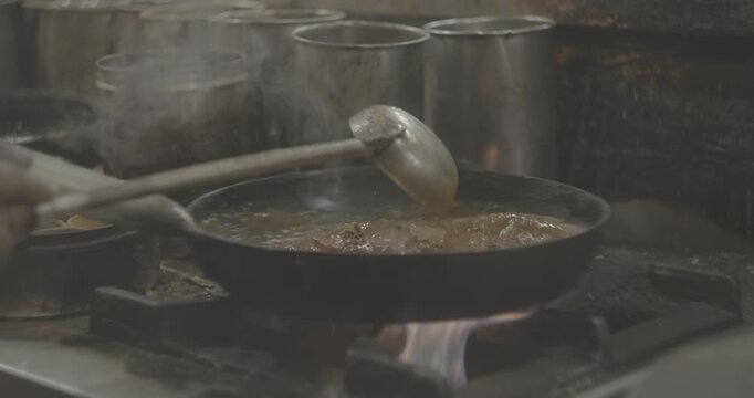 Man cooking street food Biryani on a busy street. Slow motion Biryani is a mixed rice dish, mainly popular in South Asia. It is made with rice, some type of meat chicken, goat, lamb, beef, prawn, or