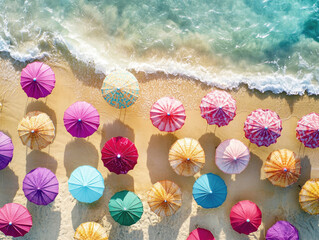 Brightly colored umbrellas create a vibrant pattern on the sandy beach. The waves gently lap at the shore under clear blue skies, inviting relaxation and enjoyment.