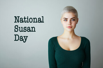 A young woman with short platinum blonde hair stands confidently against a plain background wearing an emerald green sweater. National Susan day concept