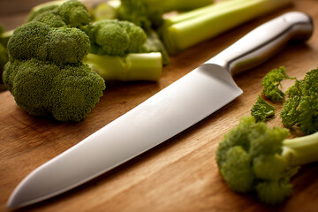 Sharp kitchen knife resting on wooden chopping board with fresh vegetables Generative AI