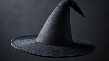 Close-up of a modern minimalist witch&acirc;s hat, clean black felt material, subtle white magical light trails, neutral background, stock-friendly composition