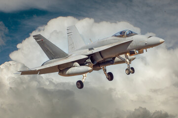 Avi&oacute;n de combate maniobrando para aterrizar con fondo de nubes.