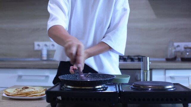 A cook pours smooth batter into a hot pan and swirls it for a perfect thin layer. Essential technique for evenly cooked, delicate crepes ideal for beginners and pros alike.