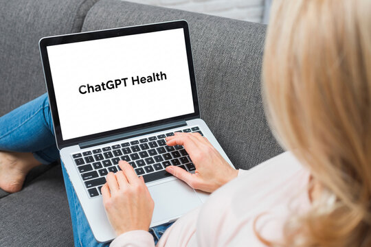 Woman using chatgpt health on laptop at home