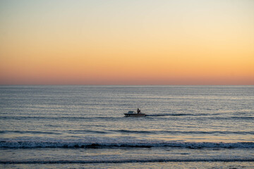 Obraz premium seascape with fishing boat at golden hour