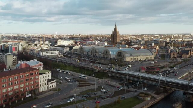 Riga Central Market zeppelin hangars near Latvian Academy of Sciences Stalinist skyscraper. Trains on Railway Bridge over Daugava river with car traffic interchange in Riga capital Latvia.