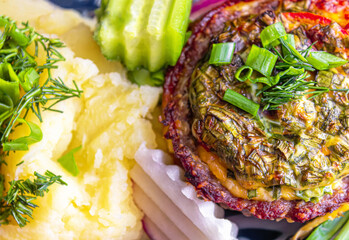 Baked meat with cheese and mashed potatoes with fresh vegetables as a side dish