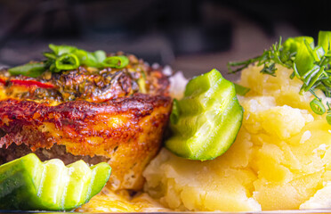 Baked meat with cheese and mashed potatoes with fresh vegetables as a side dish