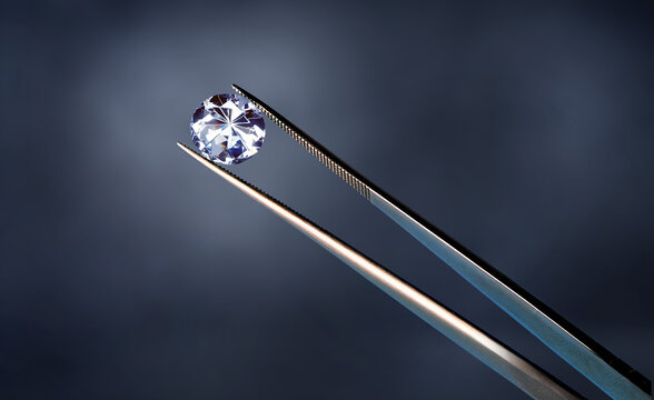 a diamond in a pair of tweezers