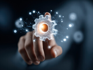 A close up of a hand reaching out to touch a glowing digital gear icon, symbolizing innovation and technology in automation.