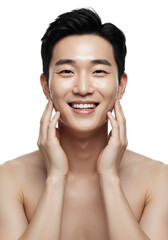Young East Asian man, early 20s, with radiant skin, smiling, gently touching his face, bare shoulders, against a transparent studio background. Concept of healthy skin and self-care