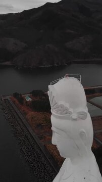 Vertical Aerial Closeup Aizu Jibo Kannon Giant spiritual Statue of Mercy with tourists in Fukushima Japan