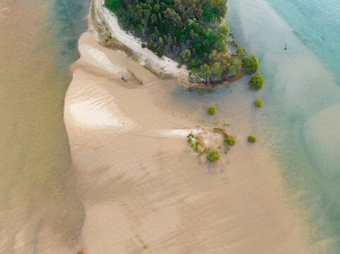 Aerial view of sand bars off the tip of a small island in a coastal river system