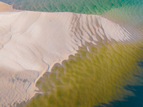 Aerial view of abstract pattern and water flow over sand in a coastal lake system