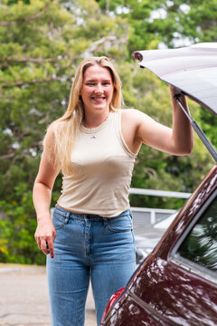 young woman closing the hatch on her car