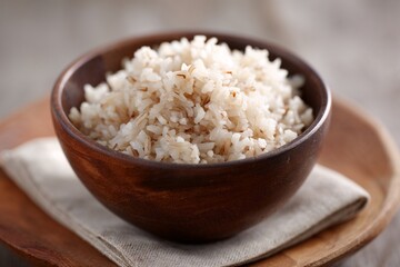 Cooked white rice served in wooden bowl on rustic background