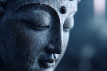 Close-up of Buddha statue face in soft blue light