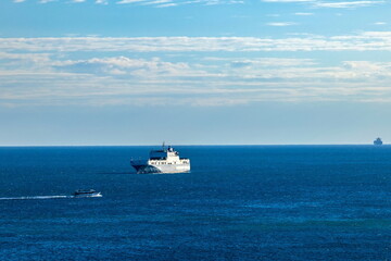 Aliscafo in viaggio con nave passeggeri e nave mercantile ancorate e in alto mare
