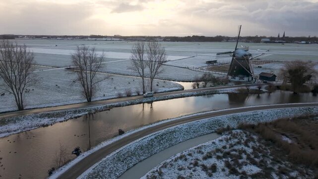Winter landscape of Abcoude and river Gein, dutch countryside with traditional windmill covered in snow