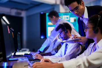 Professional financial trading team analyzing stock market trends in a modern office. Brokers with headsets discuss global investment strategies on a digital tablet at night.