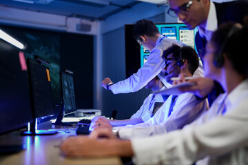 Professional financial trading team analyzing stock market trends in a modern office. Brokers with headsets discuss global investment strategies on a digital tablet at night.