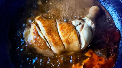 Stewing chicken with sauce in pan, in door Chiangmai Thailand.