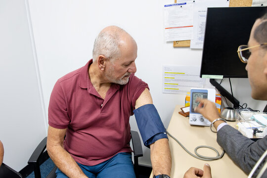 Doctor checking senior mans blood pressure