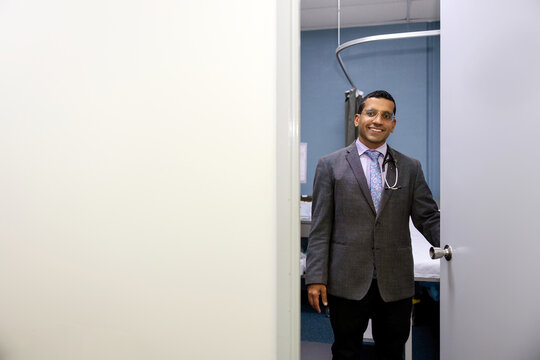 Male doctor opening clinic door