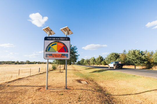 Extreme fire danger risk warning sign advising total fire ban in summer with vehicle passing by