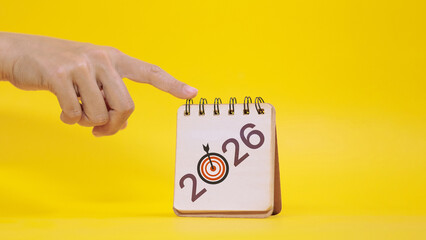 Hand Pointing at 2026 Calendar with Target Icon for New Year Goal Setting Concept