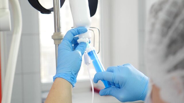 Hospital and clinic. Nurse prepares iv intravenous drip. Surgeon operates on patient in operating room. Saving lives concept. Modern medical equipment. Healthcare worker preparing Intravenous