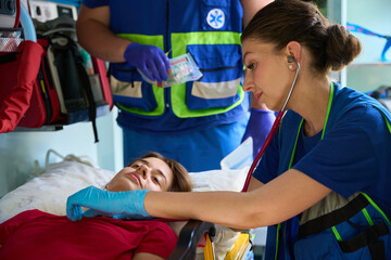 Woman patient receiving immediate medical attention in ambulance