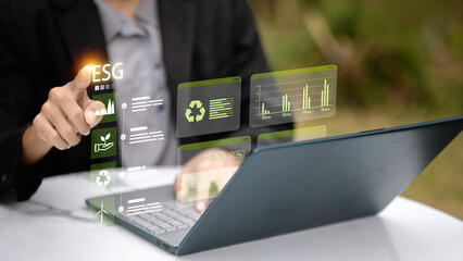 Businessman Working on Laptop with ESG Virtual Interface for Sustainable Development Reporting