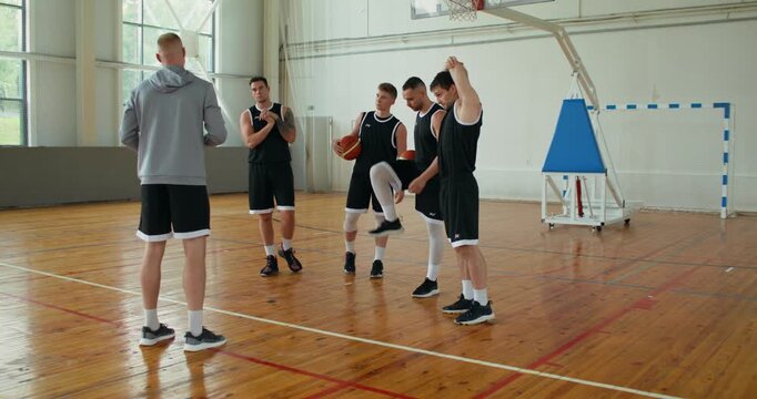 Basketball players warming up before practice. basketball players warm up before training under the guidance of the coach.