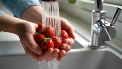 Hands gently rinse ripe strawberries under sparkling water droplets in bright kitchen capturing freshness cleanliness and everyday healthy food ritual - Powered by Adobe