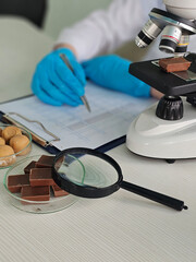 Scientist studies chocolate samples under microscope