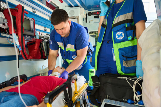 Ambulance medic preparing neck brace for injured woman
