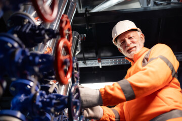 Senior engineer working controlling valves in industrial plant