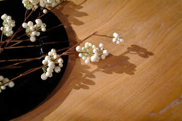 Close up of white berries of a flower, on a wooden surface
