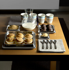 Still life with a tray of sweets, milk, sugar and cups