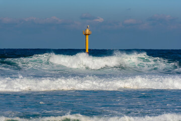 노란 등대가 있는 거친 바다