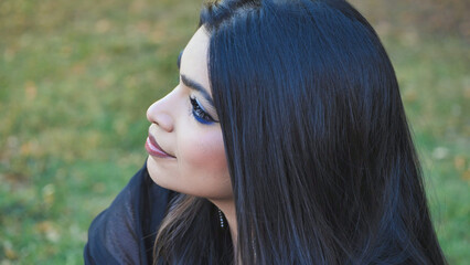Young Bangladeshi woman's profile portrait wearing blue eyeshadow in a Moscow park © Довидович Михаил
