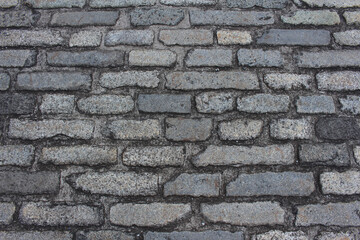 Fototapeta premium Texture of cobblestone. Pattern of sidewalk tiles in the street. Cobblestones close up background. 