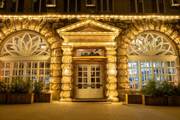 The facade of an old building, beautifully illuminated by garlands