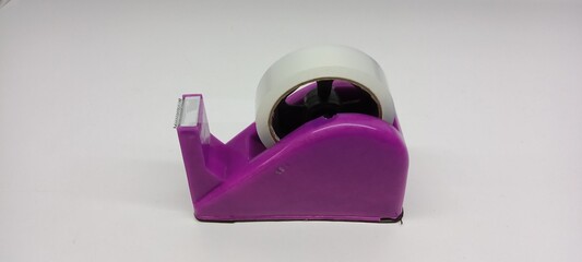 Close-up of clear duct tape with purple dispenser on white background